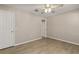 Neutral bedroom with wood-look flooring and an open doorway with a view of a walk-in closet at 1125 Blackjack Ridge St, Minneola, FL 34715
