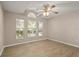 Bedroom with three windows providing ample natural light, wood-look flooring, and a modern ceiling fan at 1125 Blackjack Ridge St, Minneola, FL 34715