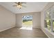 Light-filled bedroom featuring tile floors, a ceiling fan, and sliding glass doors leading to the backyard at 1125 Blackjack Ridge St, Minneola, FL 34715
