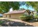 Exterior side view of a well maintained single-story home with mature landscaping and a brown shingle roof at 1125 Blackjack Ridge St, Minneola, FL 34715