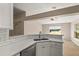 Kitchen area featuring a double sink and white cabinets with modern countertops at 1125 Blackjack Ridge St, Minneola, FL 34715