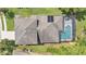 An aerial view of the roof, screened-in pool, and surrounding landscape at 141 Minniehaha Cir, Haines City, FL 33844