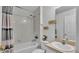 This full bathroom features a shower-tub combo, vanity and white tile at 141 Minniehaha Cir, Haines City, FL 33844