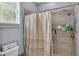 Neutral bathroom featuring a tiled shower with modern fixtures and a stylish shower curtain at 141 Minniehaha Cir, Haines City, FL 33844
