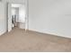 A bright bedroom with neutral walls and carpeted floors, showing a view into the hallway at 141 Minniehaha Cir, Haines City, FL 33844