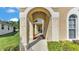Arched entryway leads to the front door, showcasing architectural detail and landscaping at 141 Minniehaha Cir, Haines City, FL 33844