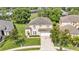 Aerial view of the home featuring a lush lawn, driveway, and partial street view at 141 Minniehaha Cir, Haines City, FL 33844