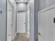 A hallway featuring multiple doorways and neutral paint, highlighting the home's layout at 141 Minniehaha Cir, Haines City, FL 33844