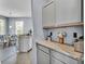 Kitchen view shows open layout with grey cabinets, granite counters, and adjacent dining area at 141 Minniehaha Cir, Haines City, FL 33844