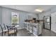 The kitchen features grey cabinets, tile backsplash, stainless steel appliances, and a counter with bar stool seating at 141 Minniehaha Cir, Haines City, FL 33844