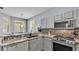 Kitchen with stainless steel appliances, stylish grey cabinetry, and granite countertops with breakfast bar at 141 Minniehaha Cir, Haines City, FL 33844
