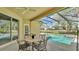 Outdoor patio featuring screened in pool, dining set, and easy access to backyard at 141 Minniehaha Cir, Haines City, FL 33844