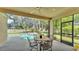 Outdoor patio area featuring screened in pool, dining set, and lush landscaping at 141 Minniehaha Cir, Haines City, FL 33844