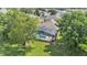Aerial view of a screened pool with lush green lawn and mature trees at 141 Minniehaha Cir, Haines City, FL 33844