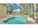 Stunning screened-in pool and spa, surrounded by lush landscaping and a spacious patio at 141 Minniehaha Cir, Haines City, FL 33844