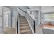 Staircase featuring black railings and carpeted steps, leading to the home's upper levels at 141 Minniehaha Cir, Haines City, FL 33844