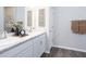 Bathroom featuring double sink vanity, marble countertops, white cabinets, and hardwood flooring at 1449 Fleur Dr, Davenport, FL 33837