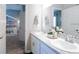Bright bathroom with double sink vanity, marble countertops, white cabinets, and doorway to sitting room at 1449 Fleur Dr, Davenport, FL 33837