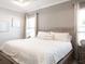 Spacious bedroom featuring tray ceiling, neutral paint, white bedding and two windows for ample natural light at 1449 Fleur Dr, Davenport, FL 33837