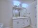 Bathroom with dual sinks, granite countertops, and a large mirror, creating a bright and functional space at 1497 Leamington Ln, Winter Haven, FL 33884