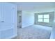 Carpeted bedroom featuring a window and an ensuite bathroom with white walls that create a bright and airy space at 1497 Leamington Ln, Winter Haven, FL 33884