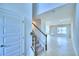 Light and bright foyer featuring a staircase, tile floor, and neutral paint palette at 1497 Leamington Ln, Winter Haven, FL 33884