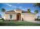 Inviting single-story home featuring a two-car garage, complemented by lush landscaping at 1513 Otter Woods Ln, Auburndale, FL 33823