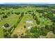Property aerial view showcasing the vast land, a serene pond, mature trees, and lush greenery, ideal for outdoor enthusiasts at 15195 Angus Rd, Polk City, FL 33868