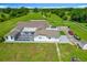 Aerial view of property featuring fenced pastures, mature trees, and long driveway, surrounded by lush green landscaping at 15195 Angus Rd, Polk City, FL 33868