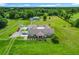 Expansive aerial view of a property with a house, pond, pool, and ample land, offering luxurious living at 15195 Angus Rd, Polk City, FL 33868