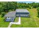 Aerial view of the home featuring an extra large barn and well-manicured lawn and landscaping at 15195 Angus Rd, Polk City, FL 33868