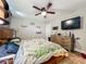 A charming bedroom featuring a ceiling fan and a wooden dresser with a TV mounted above it at 15195 Angus Rd, Polk City, FL 33868
