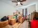 A cluttered bedroom featuring a ceiling fan and a curtained window at 15195 Angus Rd, Polk City, FL 33868