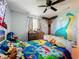 A cozy bedroom with a decorated bed frame, ceiling fan, and curtains at 15195 Angus Rd, Polk City, FL 33868