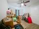 A cluttered bedroom featuring a ceiling fan and a clothing rack at 15195 Angus Rd, Polk City, FL 33868
