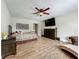 Bright bedroom with wood floors, ceiling fan, dresser, and chaise lounge chair at 15195 Angus Rd, Polk City, FL 33868