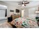This bedroom has wood flooring, a ceiling fan, and a TV mounted on the wall at 15195 Angus Rd, Polk City, FL 33868