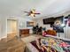 Bedroom with wood floors, ceiling fan, TV, and large desk with multiple work stations at 15195 Angus Rd, Polk City, FL 33868
