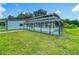 Home exterior featuring a classic farmhouse design with porch, lush lawn, and mature landscaping at 15195 Angus Rd, Polk City, FL 33868