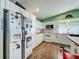 Well-lit kitchen showcasing white appliances, cabinets, and wood countertops against a vibrant green wall at 15195 Angus Rd, Polk City, FL 33868