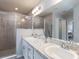Bathroom featuring double sinks, granite countertop, and tiled shower glass door at 1537 Otter Woods Ln, Auburndale, FL 33823