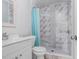 Bathroom with white vanity and a tiled shower with stylish finishes and blue shower curtain at 169 Birmingham Dr, Kissimmee, FL 34758