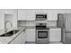 Well-lit kitchen featuring stainless steel appliances, granite countertops, and white cabinets at 169 Birmingham Dr, Kissimmee, FL 34758