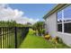 Backyard with black aluminum fence, tropical plants, and green grass at 180 Azure Mist Way, Daytona Beach, FL 32124