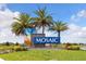 Community sign featuring three palm trees, stone trim, and a blue, mosaic-inspired design at 180 Azure Mist Way, Daytona Beach, FL 32124