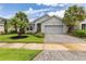 Charming home features a manicured lawn, decorative plants and a paved driveway at 180 Azure Mist Way, Daytona Beach, FL 32124