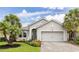 Charming home boasts a meticulously landscaped front yard, paved driveway, and manicured lawn at 180 Azure Mist Way, Daytona Beach, FL 32124