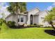 Well-manicured lawn, decorative plants, and a graceful palm tree enhance the home's curb appeal at 180 Azure Mist Way, Daytona Beach, FL 32124