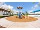 Community playground featuring modern blue play structure set on wood chip surface with covered seating, and lush surroundings at 180 Azure Mist Way, Daytona Beach, FL 32124