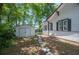 Side view of backyard featuring a white storage shed, stone pavers, and mature trees at 213 Cannon St, Lakeland, FL 33803